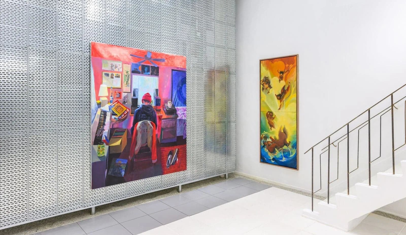 Ground floor in use — large paintings hung on the perforated steel wall beside the exposed stair rail